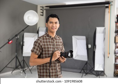 Portrait Of Young Asian Male Photographer In Studio