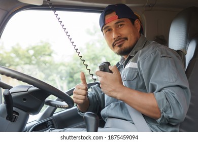 Portrait Young Asian Man Black Beard Driving Cargo Truck.Professional Truck Driver In Transportation And Delivery Business.  Man Talking On Radio Communication And Smiling Confident In Car Insurance.