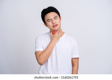 Portrait of young asian man in casual white t-shirt isolated on white background. He had a sore throat and touched his throat. Difficult to swallow. - Powered by Shutterstock