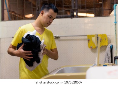 Portrait Of Young Asian Man Doing House Chores At Home