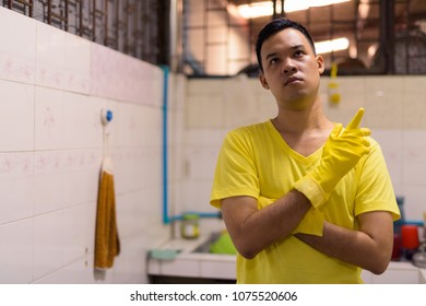 Portrait Of Young Asian Man Doing House Chores At Home