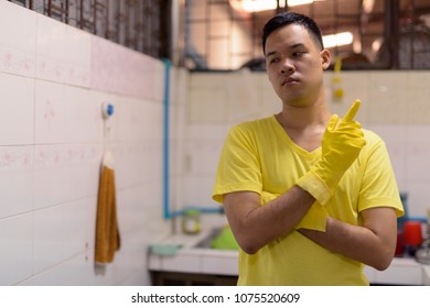 Portrait Of Young Asian Man Doing House Chores At Home