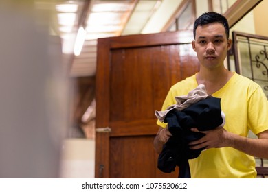 Portrait Of Young Asian Man Doing House Chores At Home