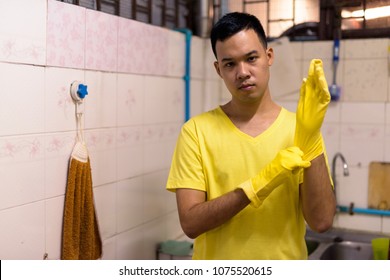 Portrait Of Young Asian Man Doing House Chores At Home