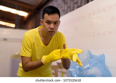 Portrait Of Young Asian Man Doing House Chores At Home