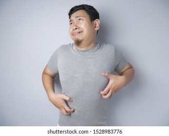Portrait of young Asian man feel itchy, scratching his body in pain