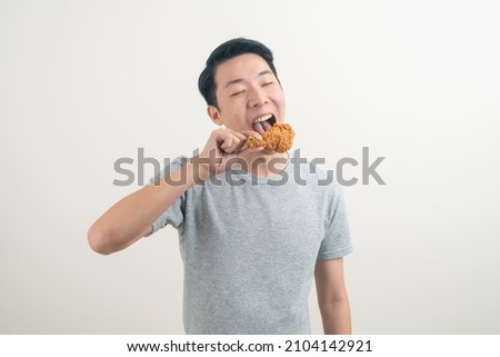 portrait young Asian man with fried chicken on hand