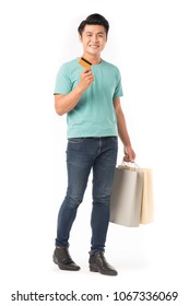 Portrait Of Young Asian Man Holding Shopping Bags And Credit Card Isolated On White