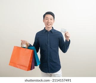 Portrait Young Asian Man Holding Credit Card And Shopping Bag On White Background