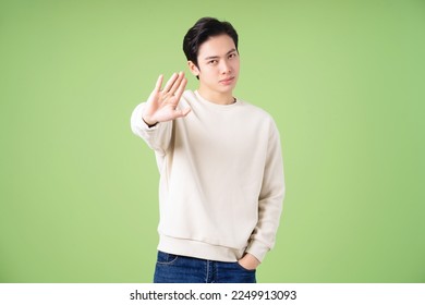 Portrait of young Asian man posing on green background - Powered by Shutterstock