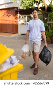 Portrait Of Young Asian Man Taking Out The Garbage At Home