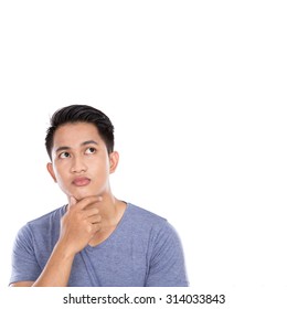 A Portrait Of A Young Asian Man Thinking Looking Up Isolated Over White Background