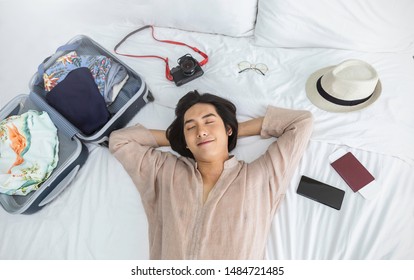 Portrait of young asian man traveler prepare suitcase for holiday vacation. Top overhead view of couple of tourists lying on bed in hotel room. Asian backpacker travel lifestyle unisex concept banner