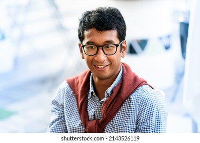 Portrait Of A Young Asian Man Wearing Glasses Standing Outdoors With A Sweater Draped Over His Shoulders Against A High Key Background