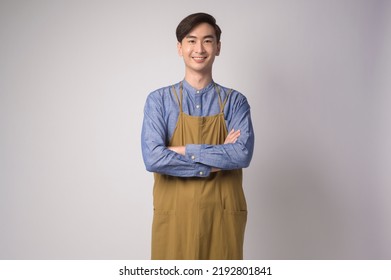 A Portrait of young asian man wearing apron over white background studio, cooking and entrepreneur concept - Powered by Shutterstock