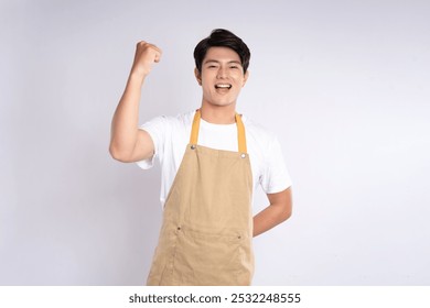 Portrait of young asian man wearing apron and posing on white background - Powered by Shutterstock