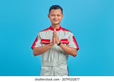 Portrait Of Young Asian Mechanic Greeting With Big Smile On His Face Over Blue Background