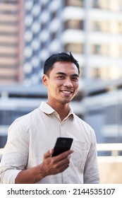 A Portrait Of A Young Asian Millenial Man On His Cellphone In The City