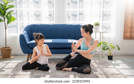 Portrait Of Young Asian Mother  Daughter Prepare For Stretching Post In Yoga Meditation. Mom And Little Girl Toddler Yoga Exercise On Yoga Mat At Home. Together Lifestyle, Mother's Day Concept