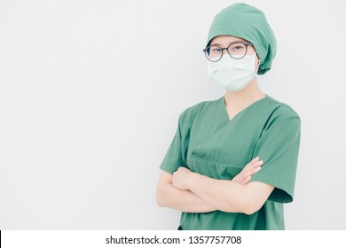 Portrait Of Young Asian Nurse With Surgeon Uniform, Wearing A Surgical Mask For Protection From Inhaling Airborne Bacteria Or Virus Disease.