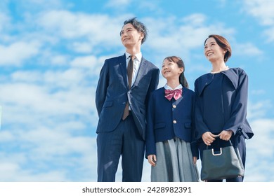 portrait of young asian parents and school girl relaxing outdoors - Powered by Shutterstock