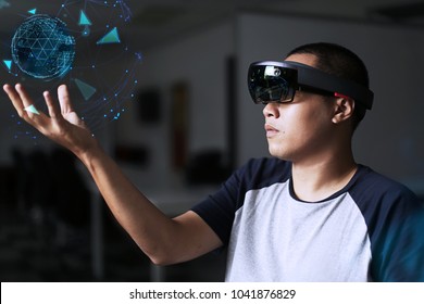 Portrait of young asian student with 3D virtual reality glasses Microsoft hololens | Men experiments virtual reality world