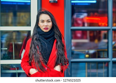 Portrait of a young Asian woman in a coat on a city street - Shutterstock ID 1276521025