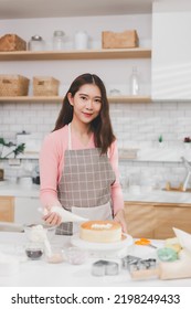 Portrait Young Asian Woman Cooking And Decoration Cake With Cream. Pastry Chef In The Kitchen Decorating Birthday Cake. Teacher Instructor Cake Class Online Course, Cooking And Pastry Skills