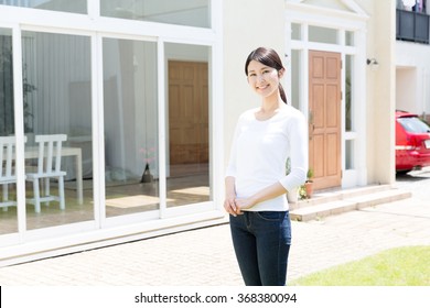 Portrait Of Young Asian Woman Front Ob House