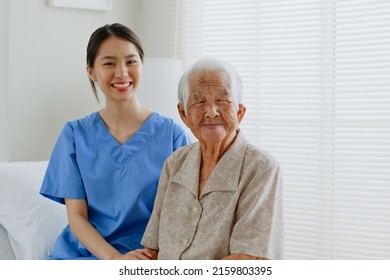 Portrait Of Young Asian Woman, Nurse, Caregiver, Carer Of Nursing Home And Senior Asian Woman Smiling At Home. Look At Camera