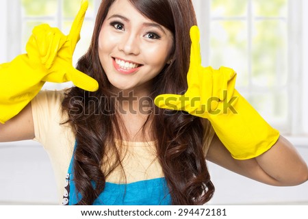 A portrait of a Young asian woman playing around with a  yellow latex gloves on