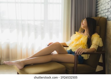 Portrait young asian woman relax happy smile on sofa chair in living room interior