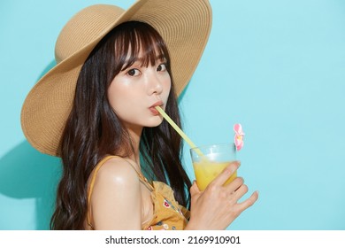 Portrait Of Young Asian Woman In Resort Fashion On Blue Background