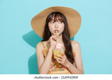 Portrait of young Asian woman in resort fashion on blue background - Powered by Shutterstock