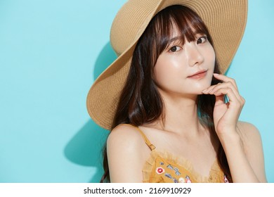 Portrait Of Young Asian Woman In Resort Fashion On Blue Background