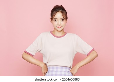 Portrait of young Asian woman in sporty fashion on pink background - Powered by Shutterstock