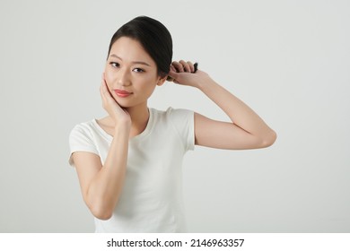 Portrait Of Young Asian Woman Twisting Hair And Touching Her Face