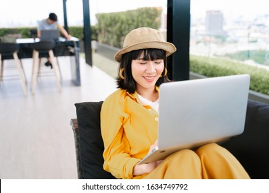 Portrait Of Young Asian Woman Using Laptop To Work In The Rooftop With Happy And Relax.