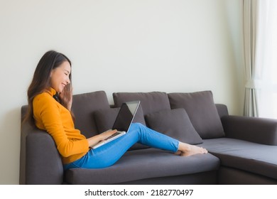 Portrait Young Asian Woman Using Laptop Computer Note Book On Sofa For Work In Living Room