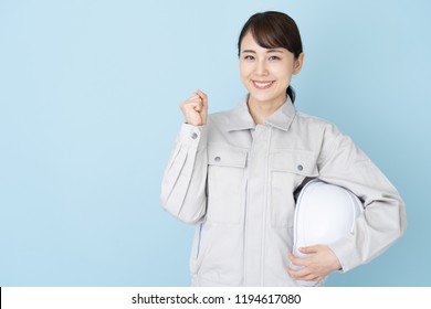 Portrait Of Young Asian Woman Wearing Working Clothes On Blue Background