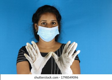 
Portrait Of Young Asian Woman Wearing Face Mask And Gloves, Hand Blocking And Looking At Camera
Indoor Studio Shoot Isolated On Blue Background, Coronavirus Concept