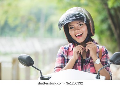 A Portrait Of A Young Asian Woman Wearing A Helmet Before Riding A Motorcycle On A Park