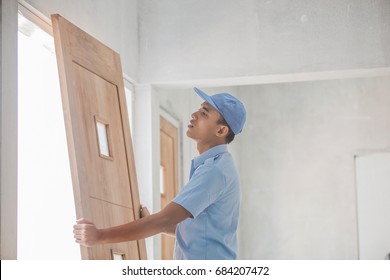 portrait of young asian worker installing doors