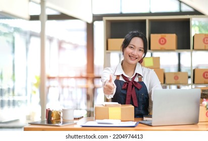 Portrait Young Attractive Asia Female Owner Startup Business Look At Camera Work Happy With Box At Home Prepare Parcel Delivery In Sme Supply Chain, Procurement, Omnichannel Commerce Online Concept.
