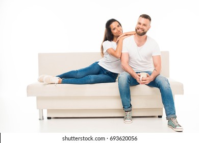 'portrait Of Young Attractive Couple Sitting On Couch, Isolated On White