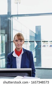 Portrait Of Young Attractive Passenger Service Agent Standing In Airport Gate