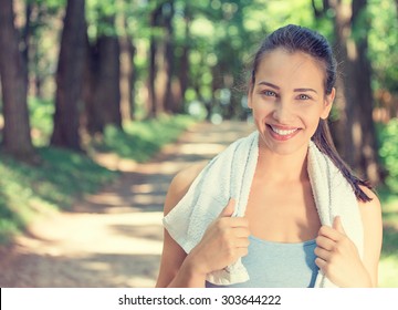 Portrait young attractive smiling fit woman with white towel resting after workout sport exercises outdoors on a background of park trees. Healthy lifestyle well being wellness happiness concept - Powered by Shutterstock