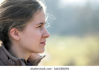 Portrait of young attractive woman enjoying warm sunny day in early spring outdoors. - Shutterstock ID 1661300296