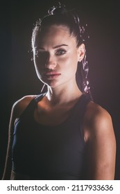 Portrait of a young attractive woman sportswoman on a black background. Concept for sports motivation.