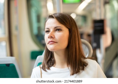 Portrait of young attractive woman traveling in modern streetcar